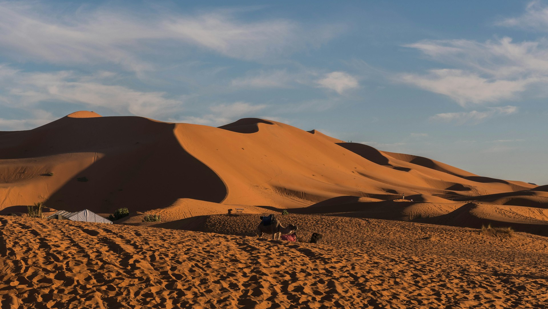 a group of people sitting on top of a sandy hill